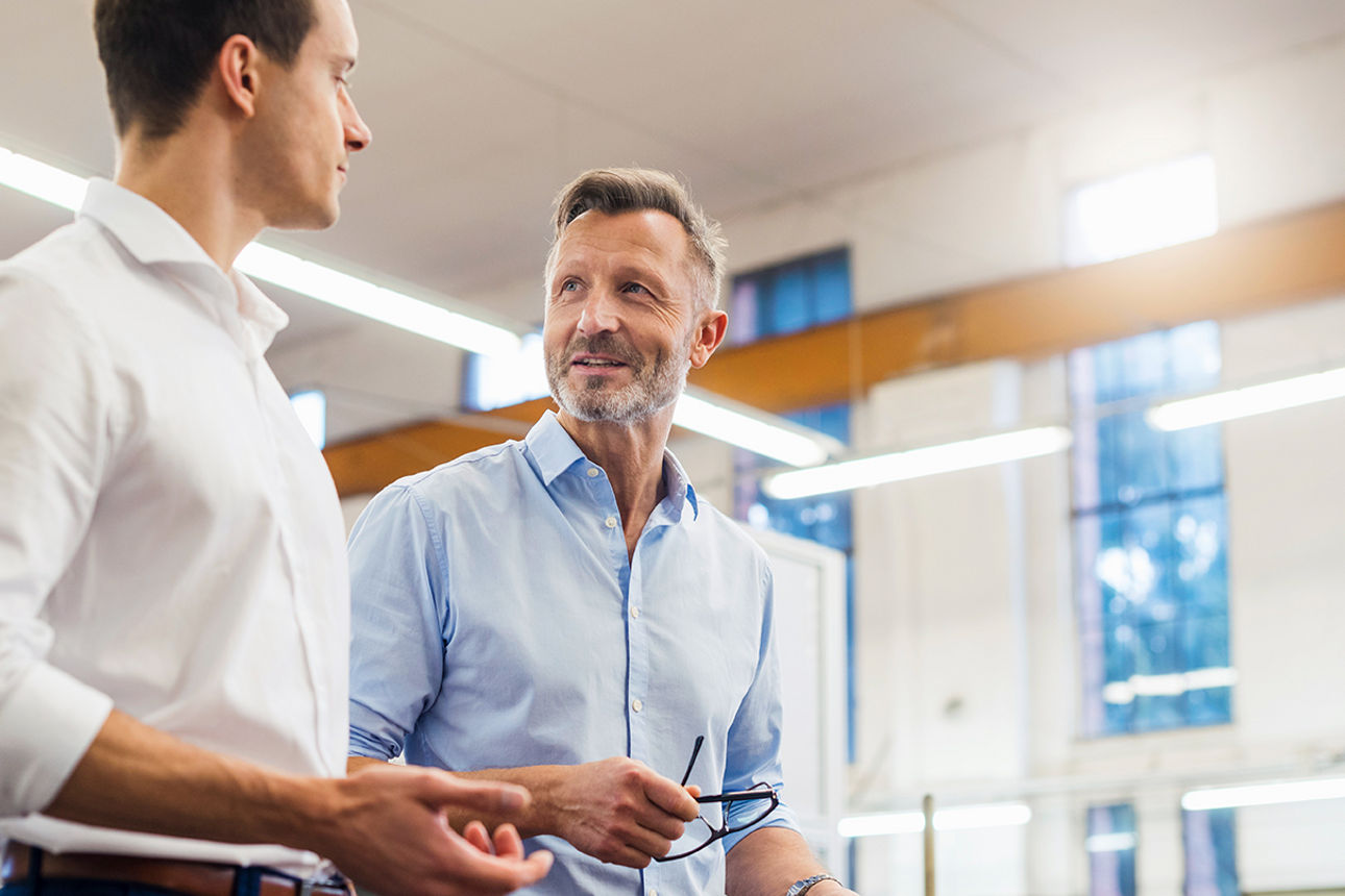 Männer im Gespräch in Lagerhalle