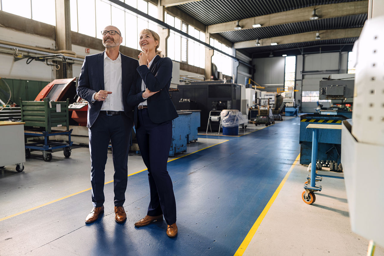 Mann und Frau in einer Fabrikhalle