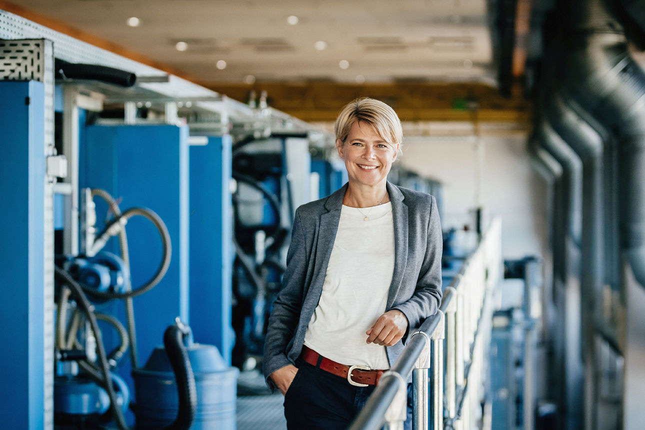 Frau mt kurzen blonden Haaren in Fabrikraum