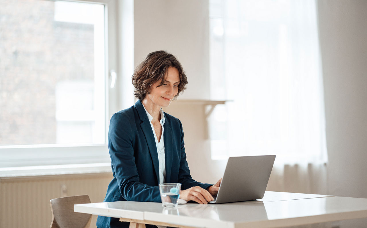 Frau mit Laptop an einem Schreibtisch