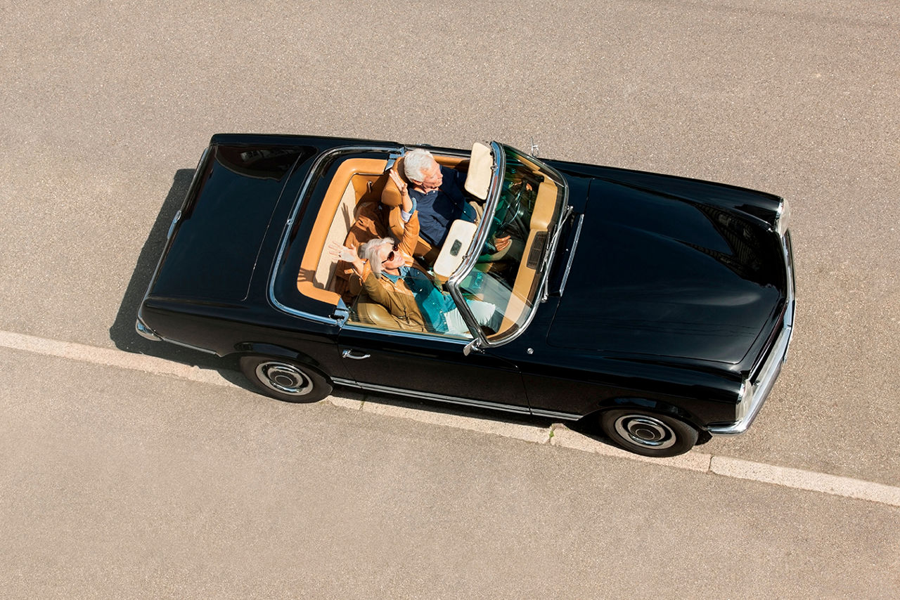 Frau und Mann in einem Oldtimer Cabrio