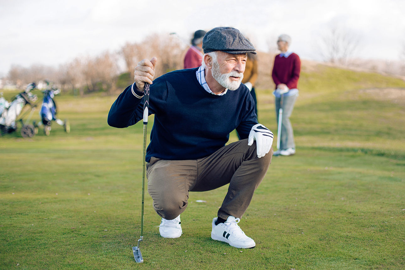 Älterer Mann spielt mit seinen Freunden Golf