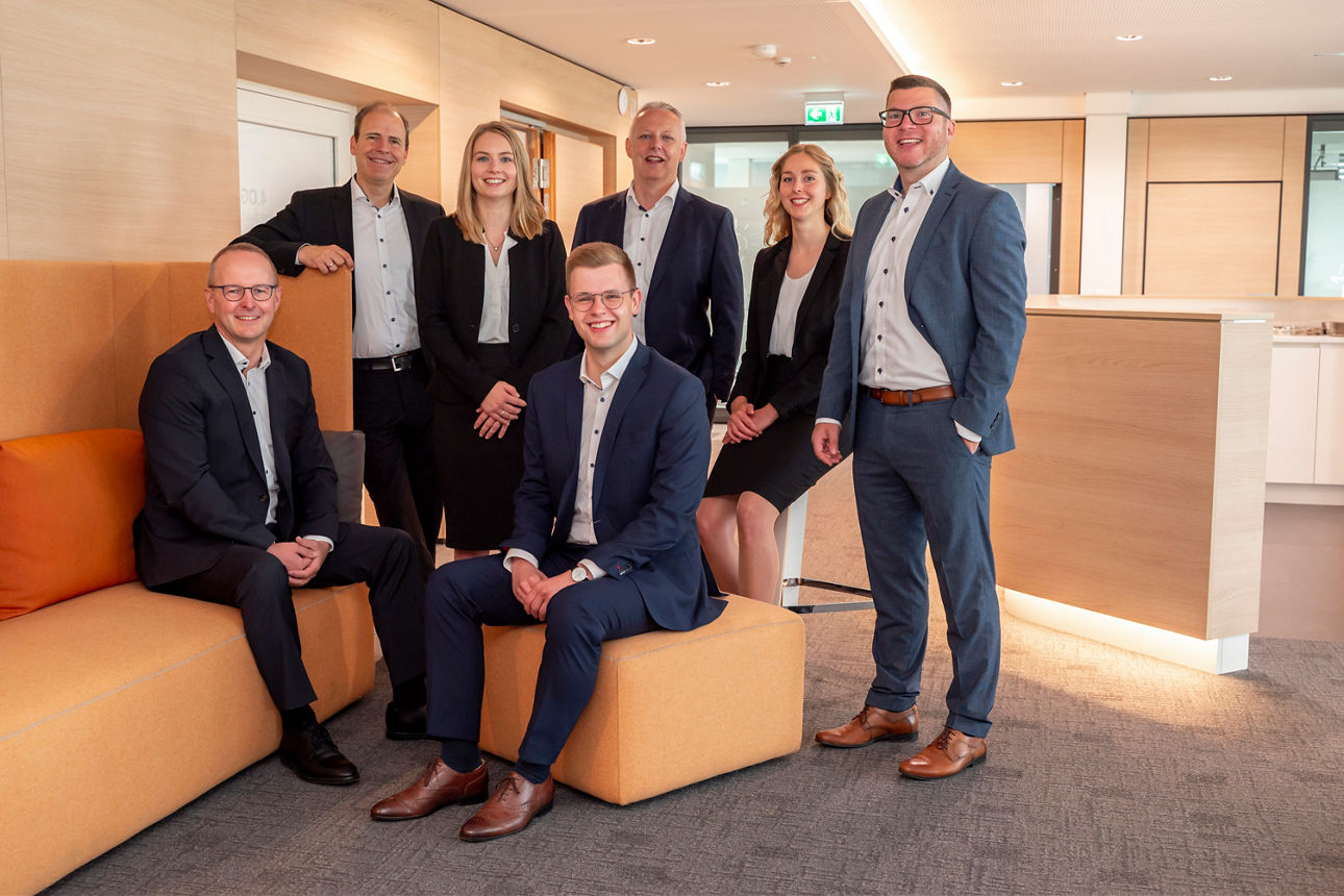 Fünf Männer und zwei Frauen stehen beieinander