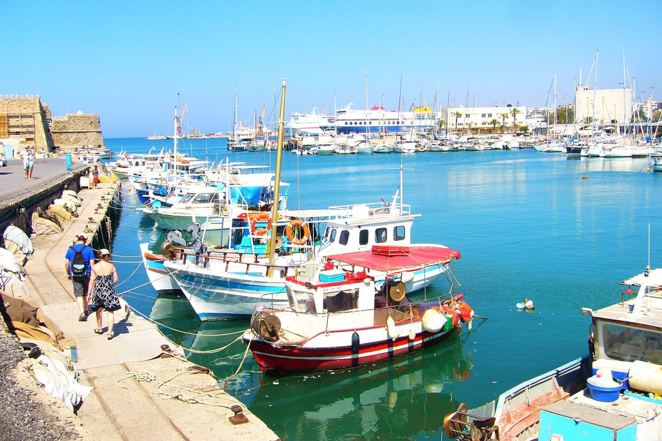 Antike Ruinen mit farbigen Säulen und Wandmalerei stehen unter blauem Himmel.