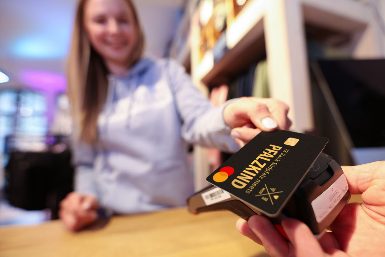 PFALZKIND GoldCard wird von einer jungen Frau über den Verkaufstresen gezeigt.