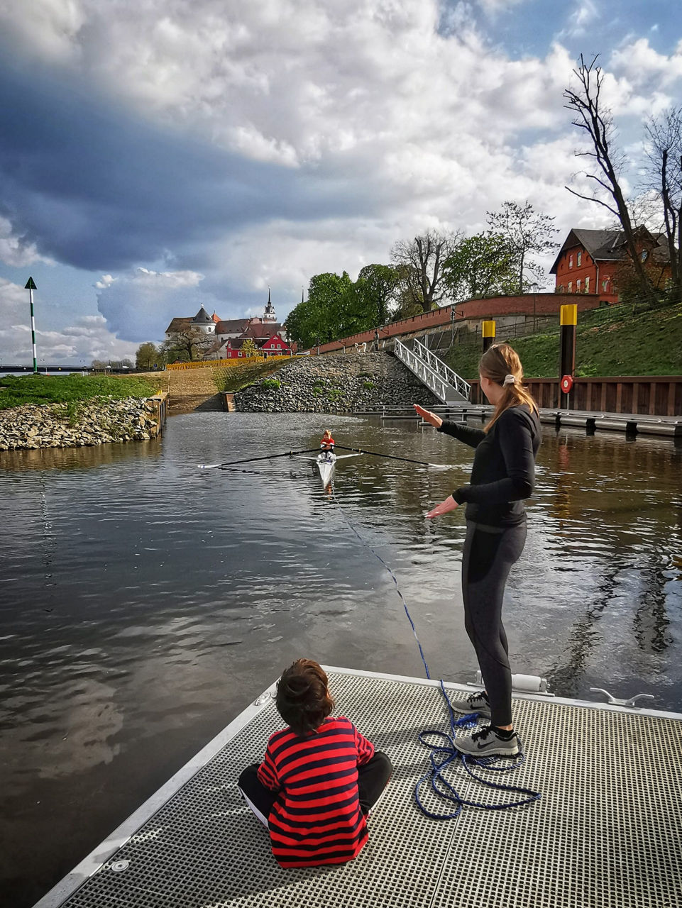 Junge und Mädchen auf einem Steg am Wasser