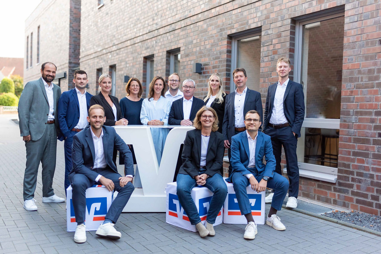 Team Privatkundenberatung steht um ein Volksbank-V Rednerpult