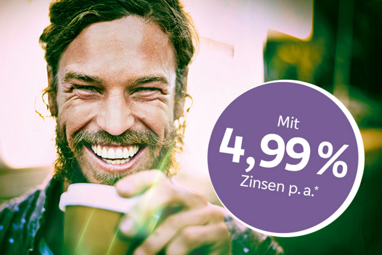 Junger Mann lächelt in Kamera und hält Kaffeebecher in der Hand