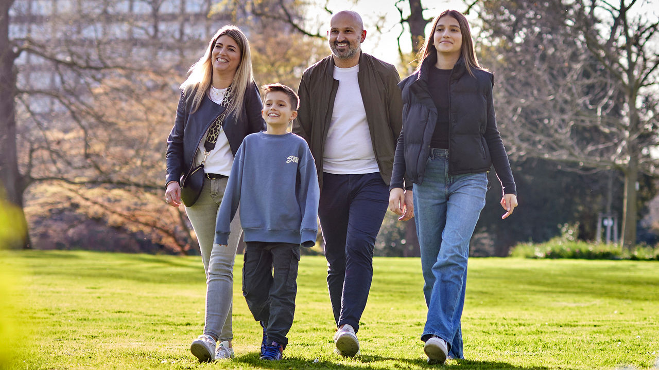 Familie die durch den Park spazieren geht