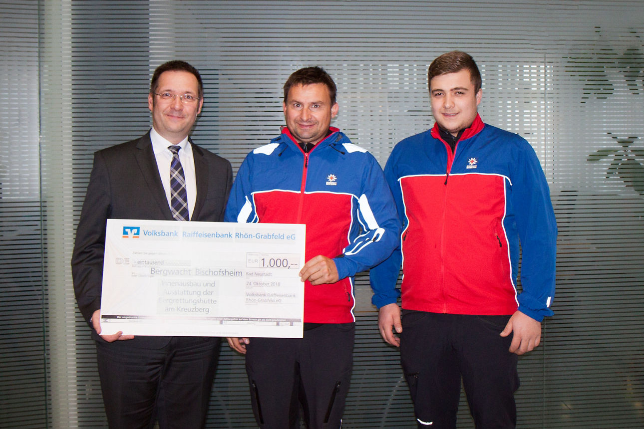 Drei Männer sind aud dem Bild, zwei halten einen Spendenscheck