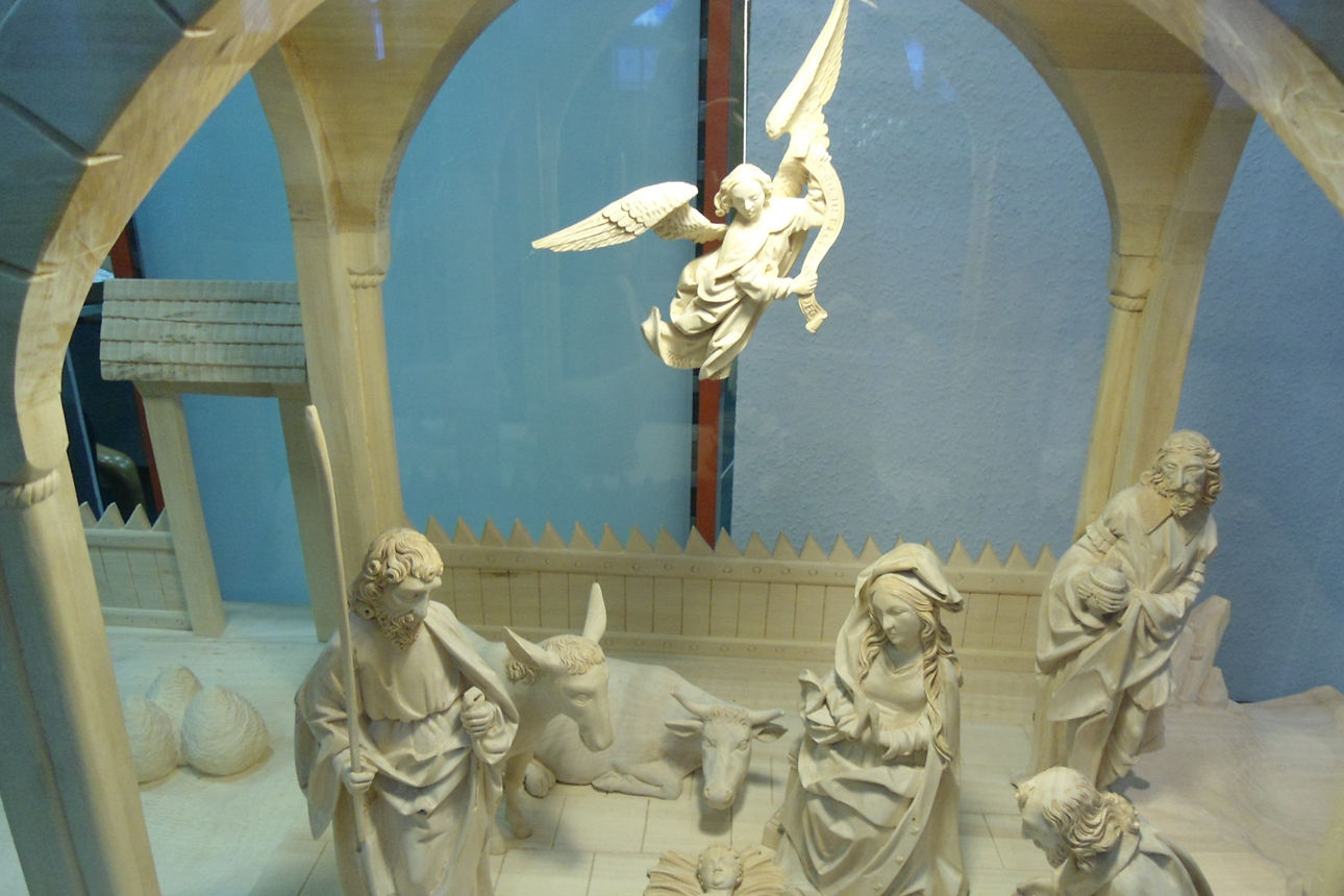 Auf dem Bild ist eine Futterkrippe mit dem Christus-Kind und weiteren Personen, sowie einem Engel zu sehen 