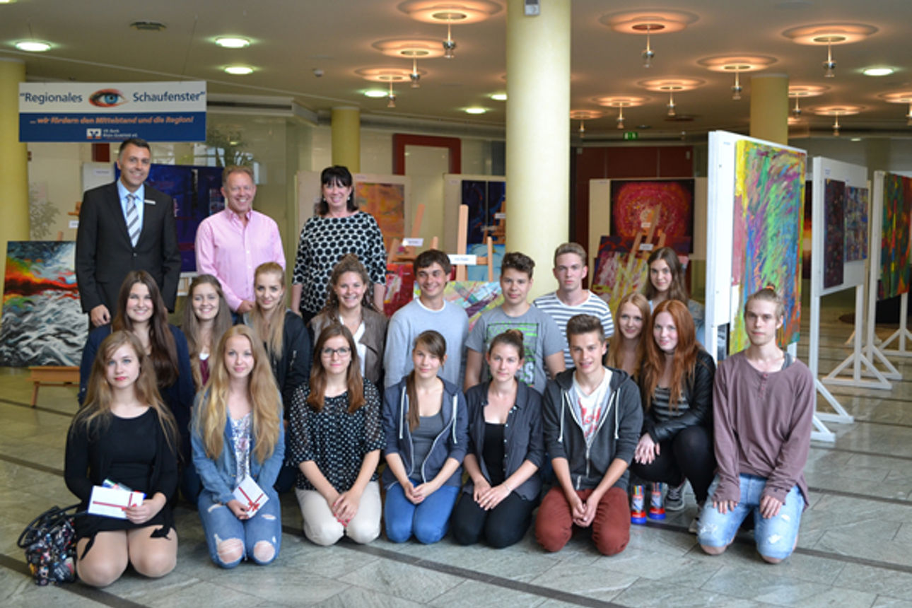 Eine Gruppe von menschen kniet auf dem Boden während hinter Ihnen drei Erwachsene stehen