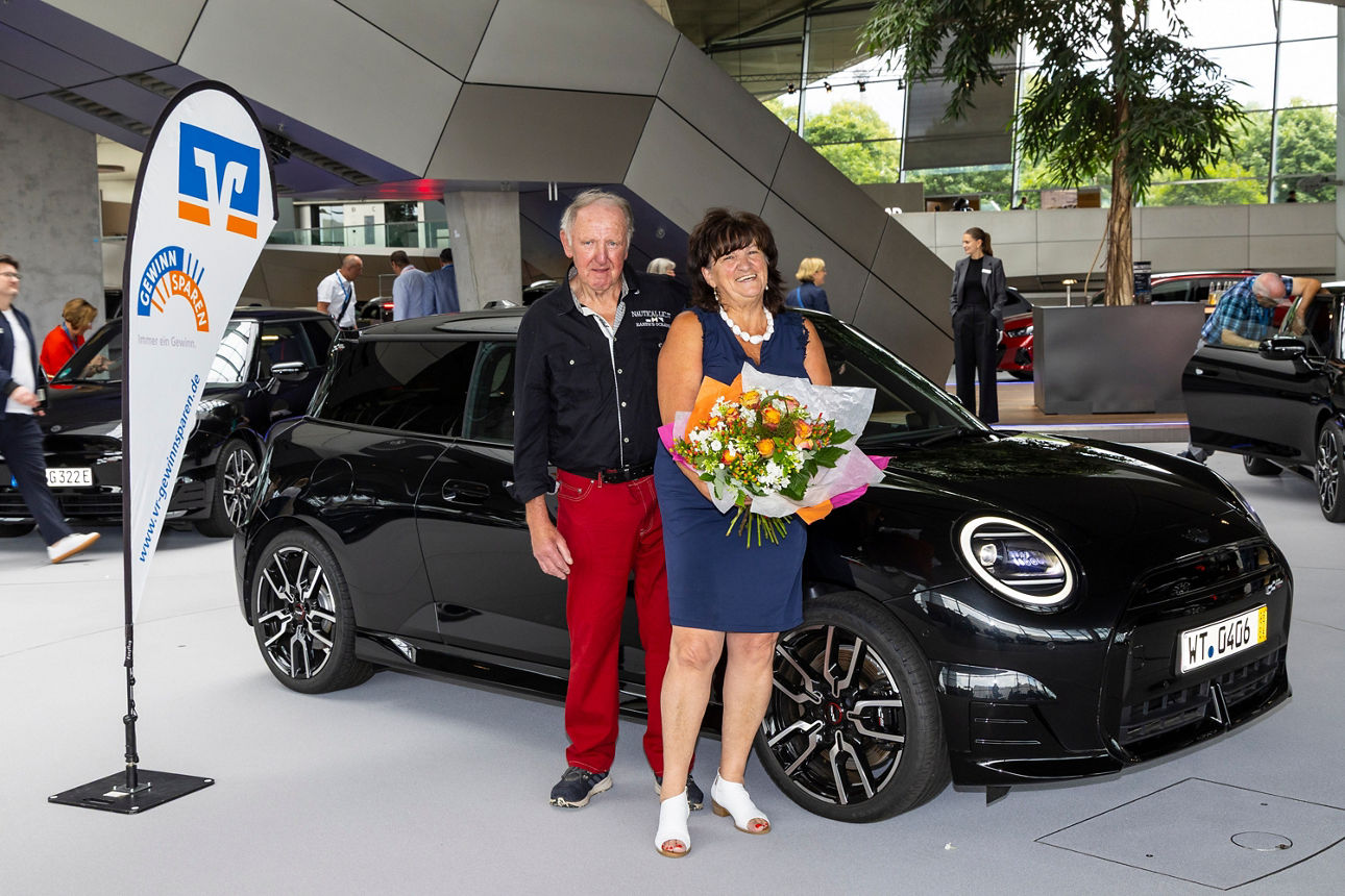 Die Gewinnerin steht vor ihrem Gewinn. Ein neuer Mini Cooper.