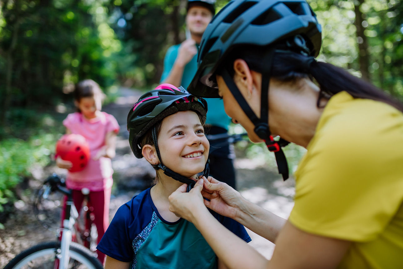 Junge Familie bereiten sich auf eine Fahrradtour in der Natur vor.