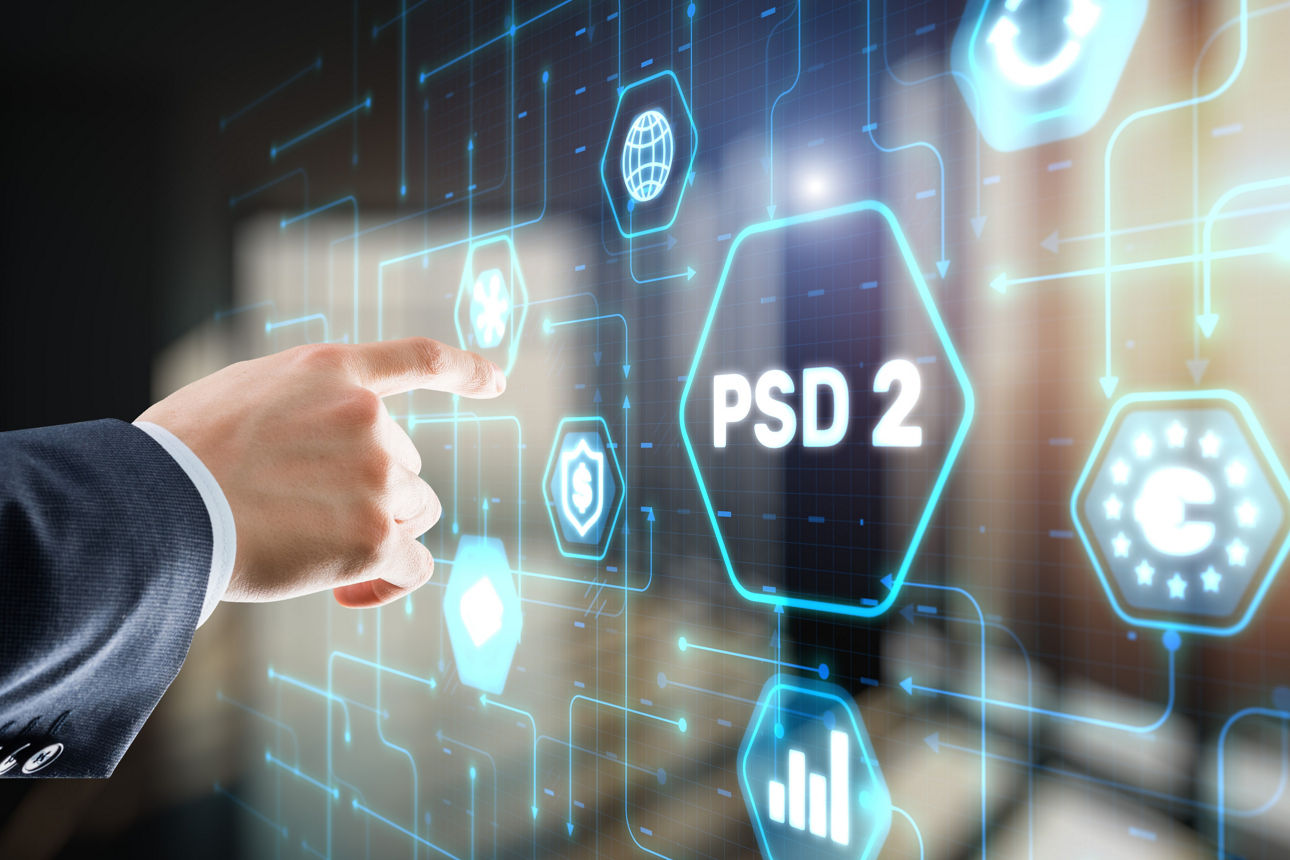 Ein männlicher Arm deutet auf eine digitale Tafel mit einem Symbol, in dem das Wort PSD2 steht.
