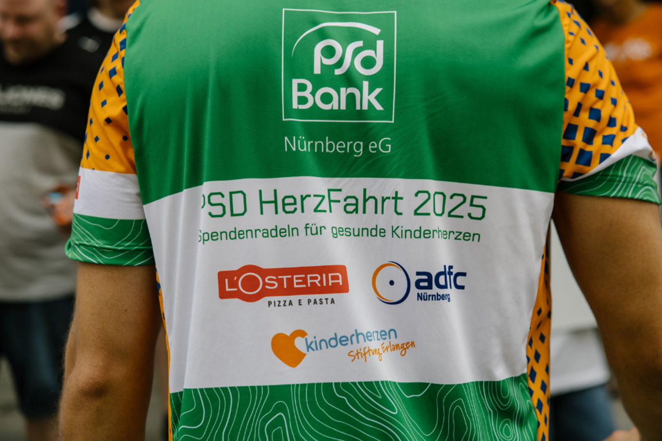 Das PSD-HerzFahrt-T-Shirt 2025 ist grün und trägt unser Logo sowie die Logos der Sponsoren ADFC, Kinderherzen e. V. und LOste