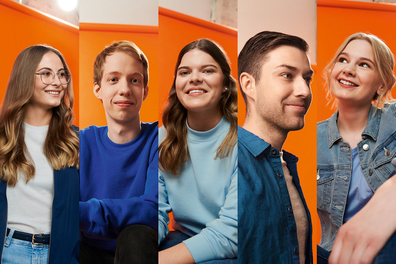 Fünf verschiedene Jugendliche posieren vor einem orangenen Hintergrund und lächeln freundlich in die Kamera