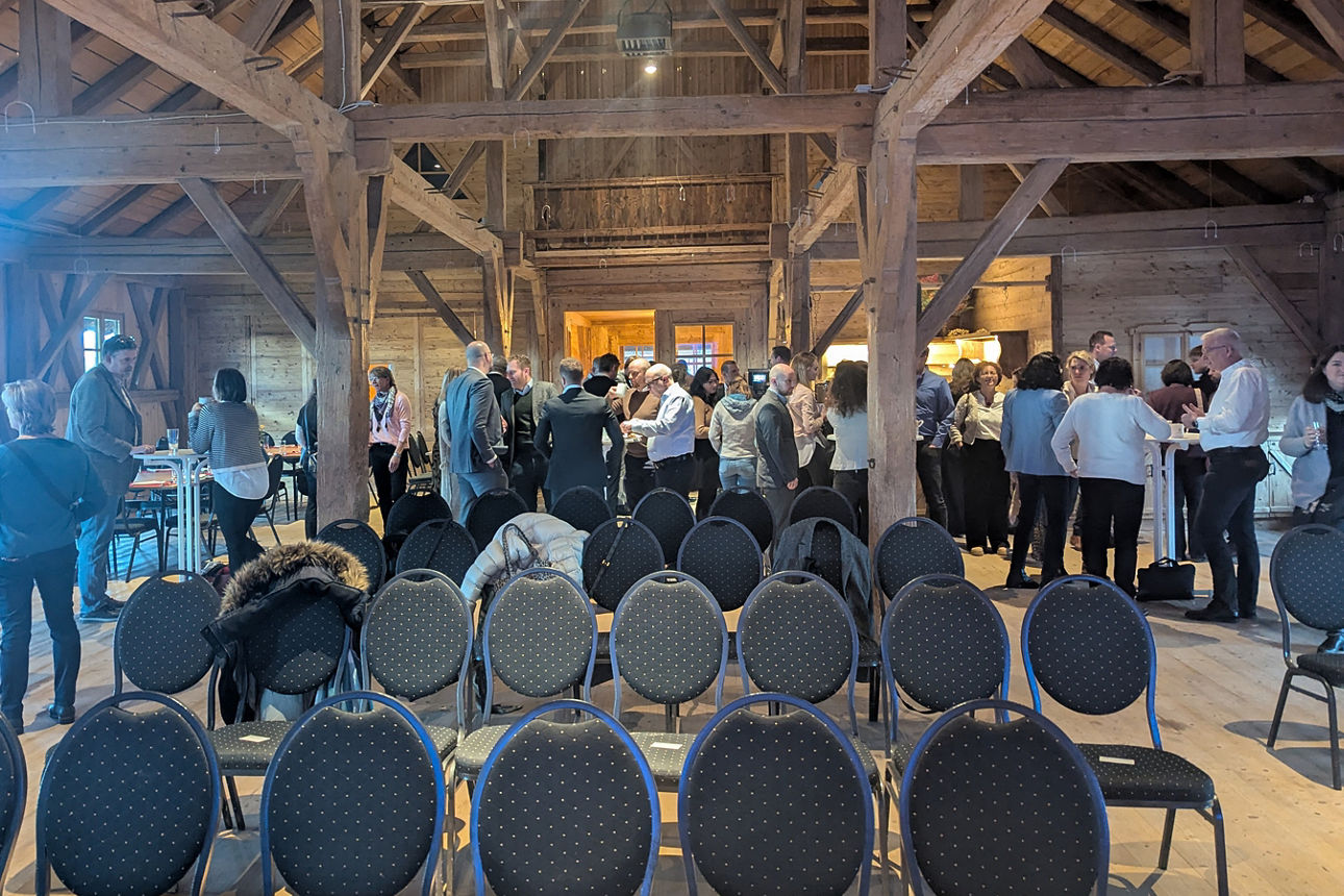 Große Menschensammlung versammelt sich in einer Scheune.