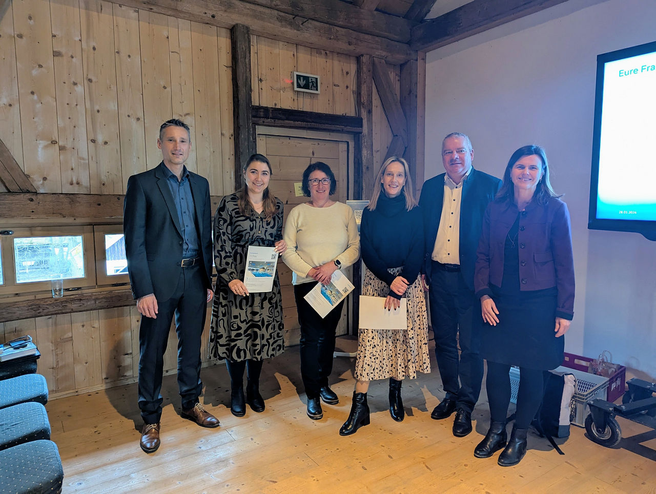 Sechs Personen lächeln freundlich in die Kamera