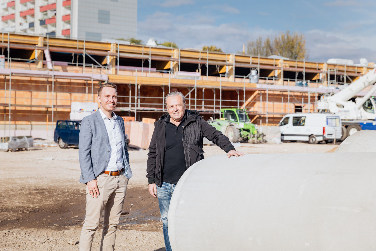 Baustelle eines im Bau befindlichen Fachmarktzentrums mit Rohbau, Gerüstkonstruktionen, Baumaschinen und gelagerten Betonfertigteilen im Außenbereich von „PZ Marktbau“