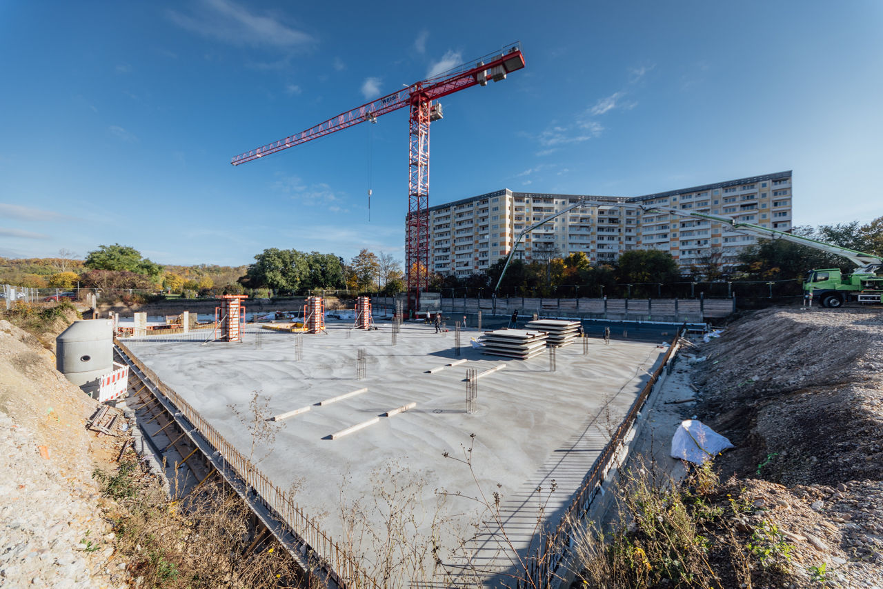 Gesamtansicht der Bodenplatte eines Neubauprojekts von „PZ Marktbau“ mit sichtbarem Kran, verlegten Bewehrungselementen und vorbereiteten Fundamentbereichen als Grundlage für den weiteren Baufortschritt
