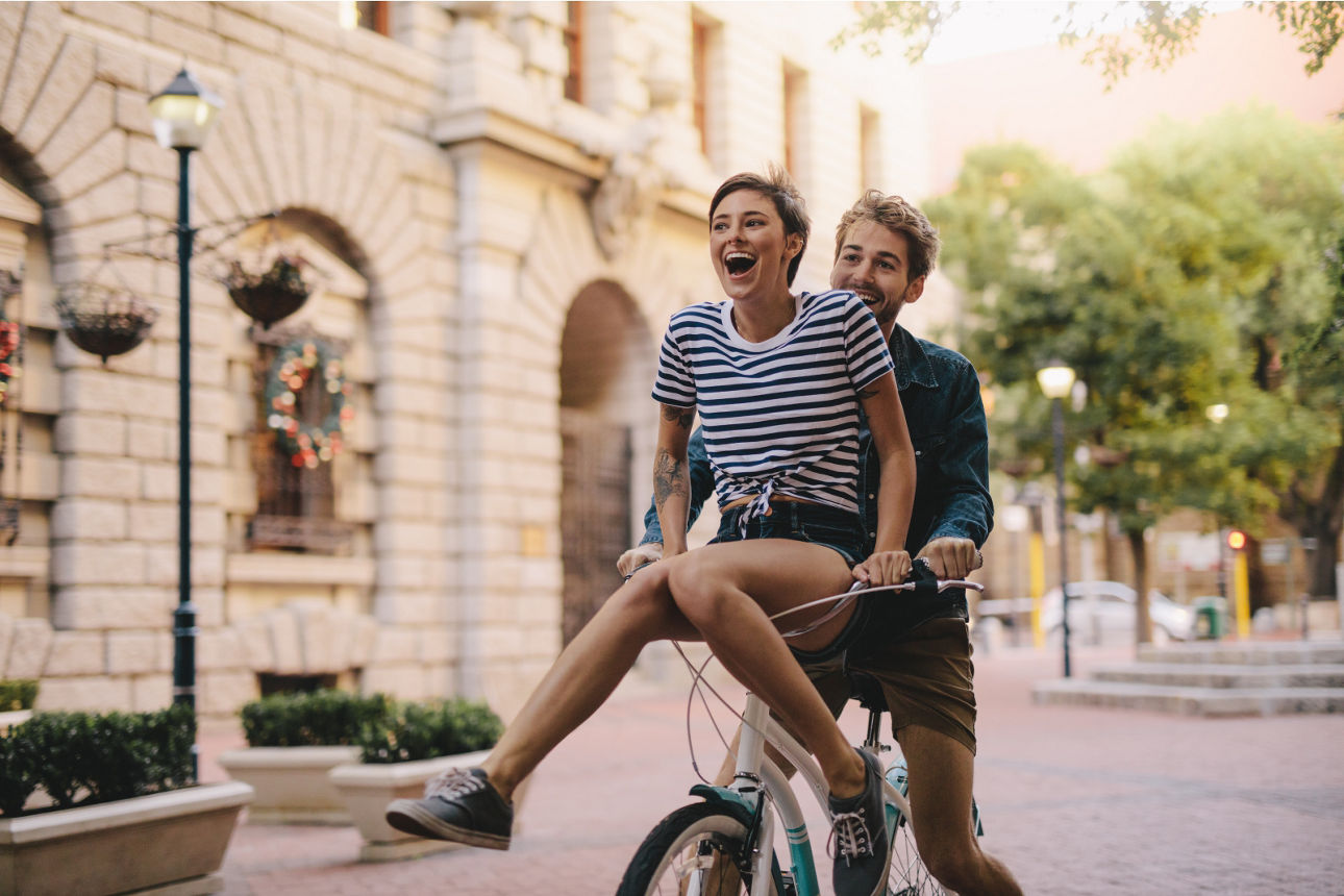 Mann fährt Fahrrad und die Frau sitzt auf dem Lenker