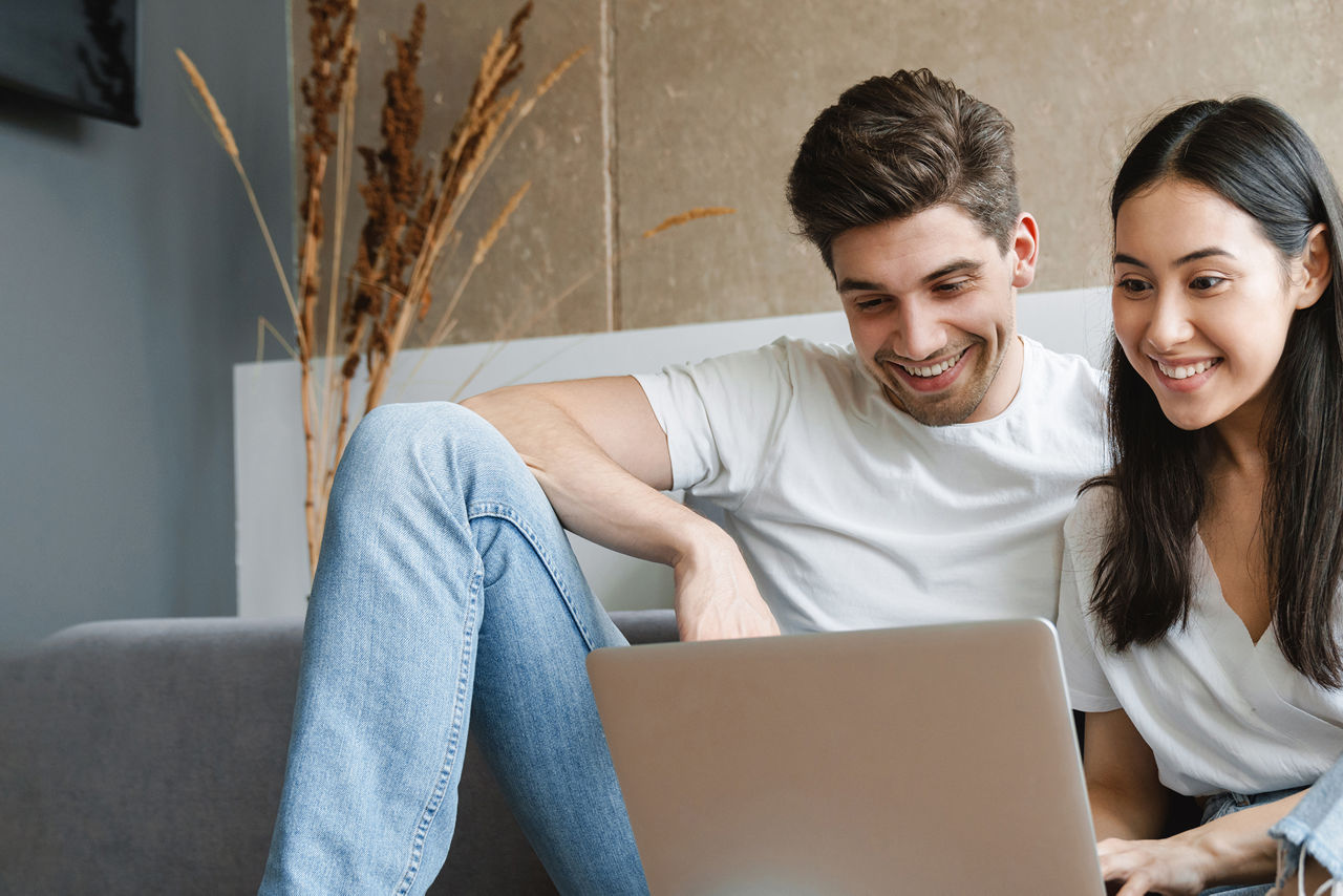 Mann und Frau mit Laptop auf der Couch