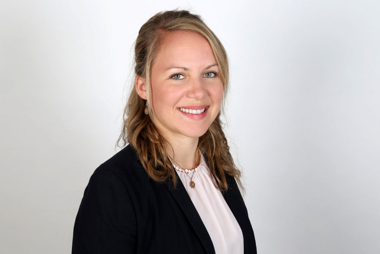 Eine lächelnder Frau schaut in die Kamera.