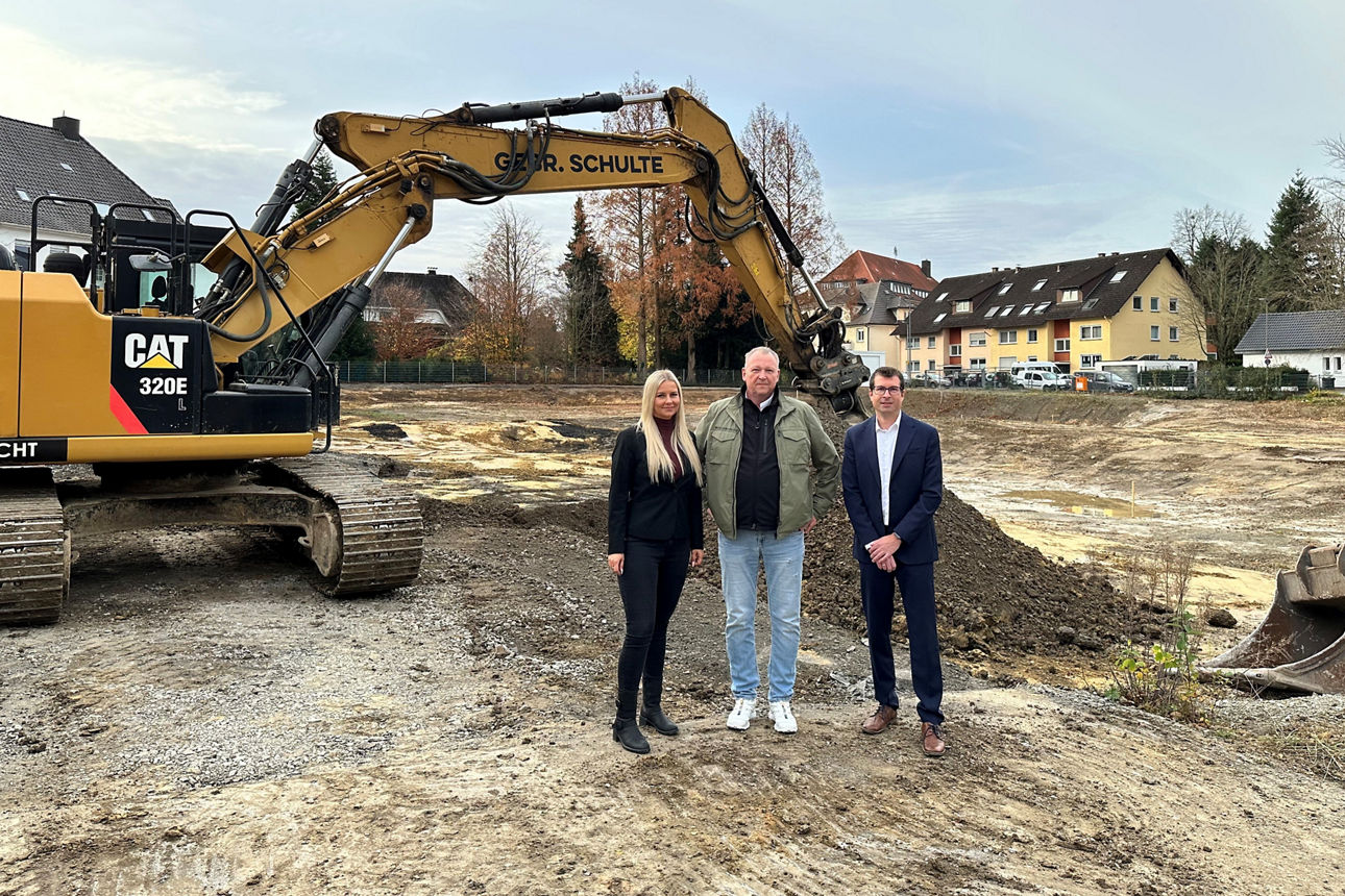 v.l.n.r.: Karoline Dlugosch, Olaf Klüsener und Andreas Furmaniak stehen vor einem Bagger auf der Baustelle