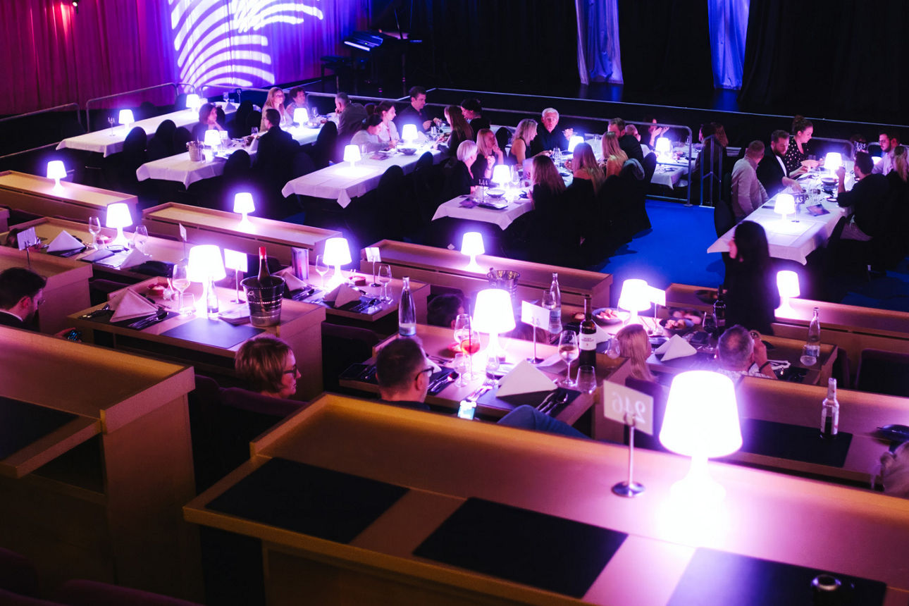 An mehreren Tischen sitzen die Leute beim Abendessen Palais Landau