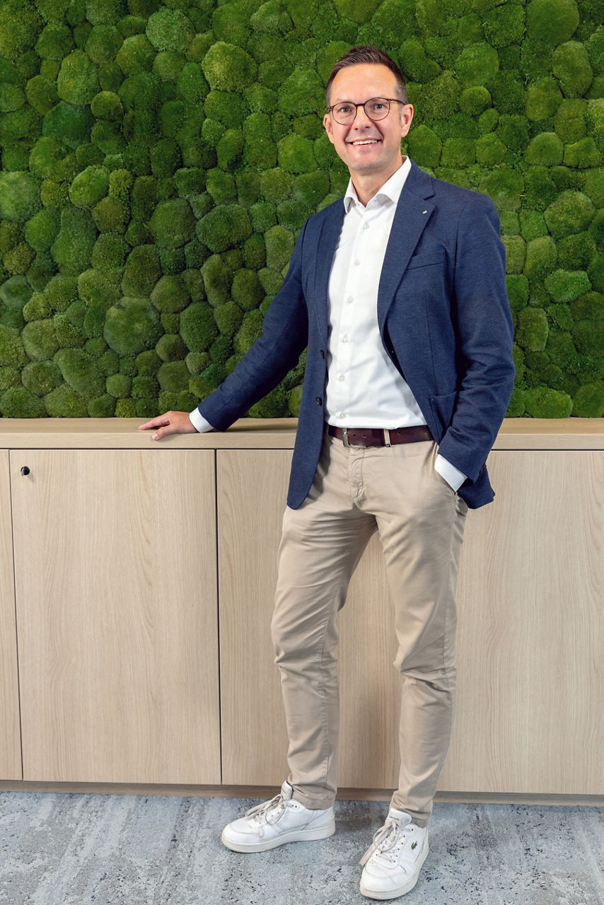 André Pannier, Bereichsleiter Vertriebsregionen steht im Volksbankhaus Soltau vor einer moosbegrünten Wand