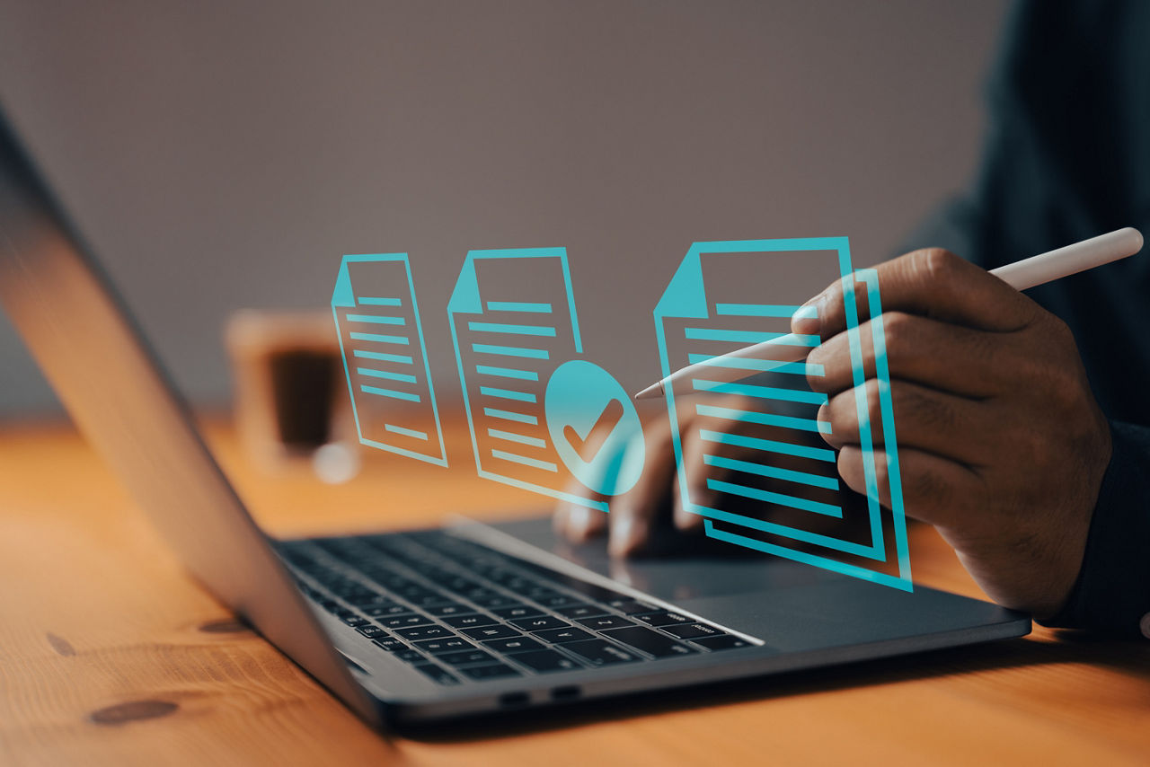 Laptop mit der Anzeige von drei digitalen Dokumenten 