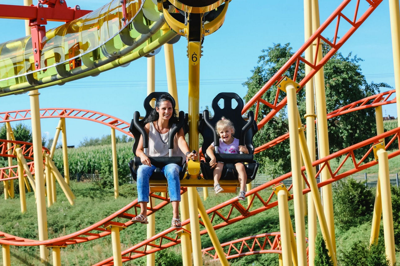Mutter mit Kind fährt gemeinsam Achterbahn im Schwabenpark.