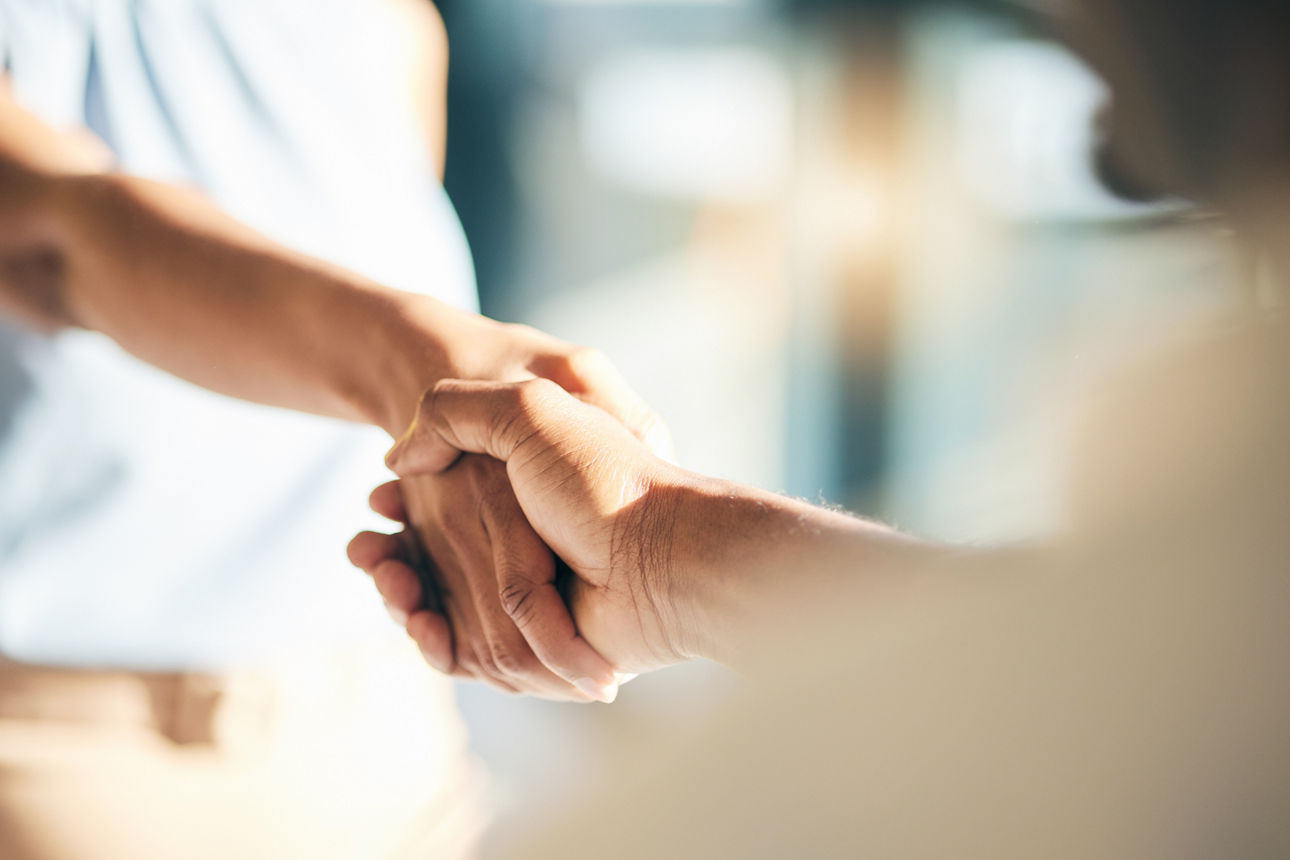 Vier Hände mit jeweils einem Puzzelstück