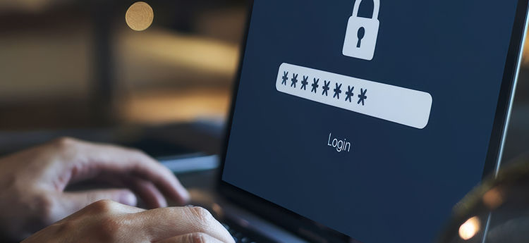Laptop mit Schloss und Passworteingabe auf dem Bildschirm und Hände auf der Tastatur