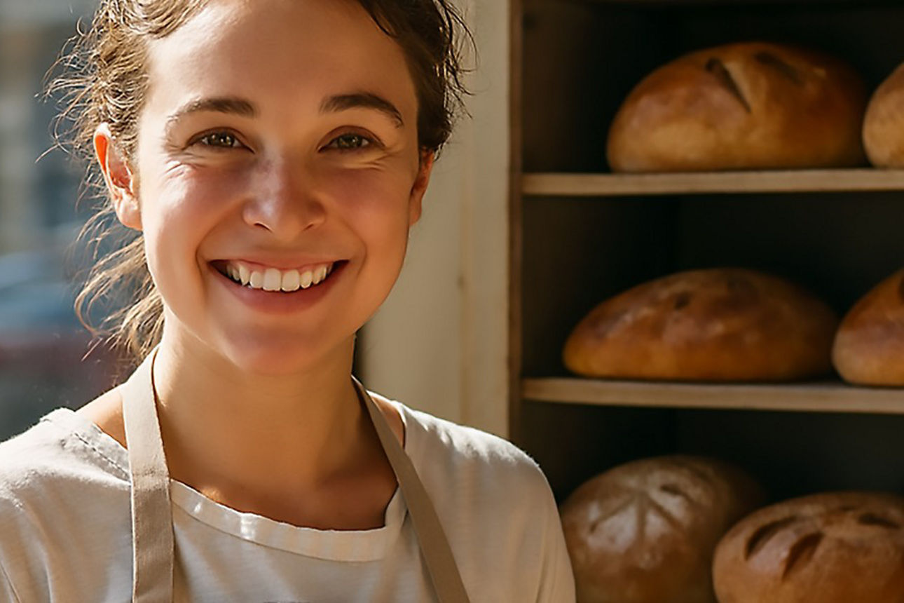 Bäckerin steht vor ihrem Brot