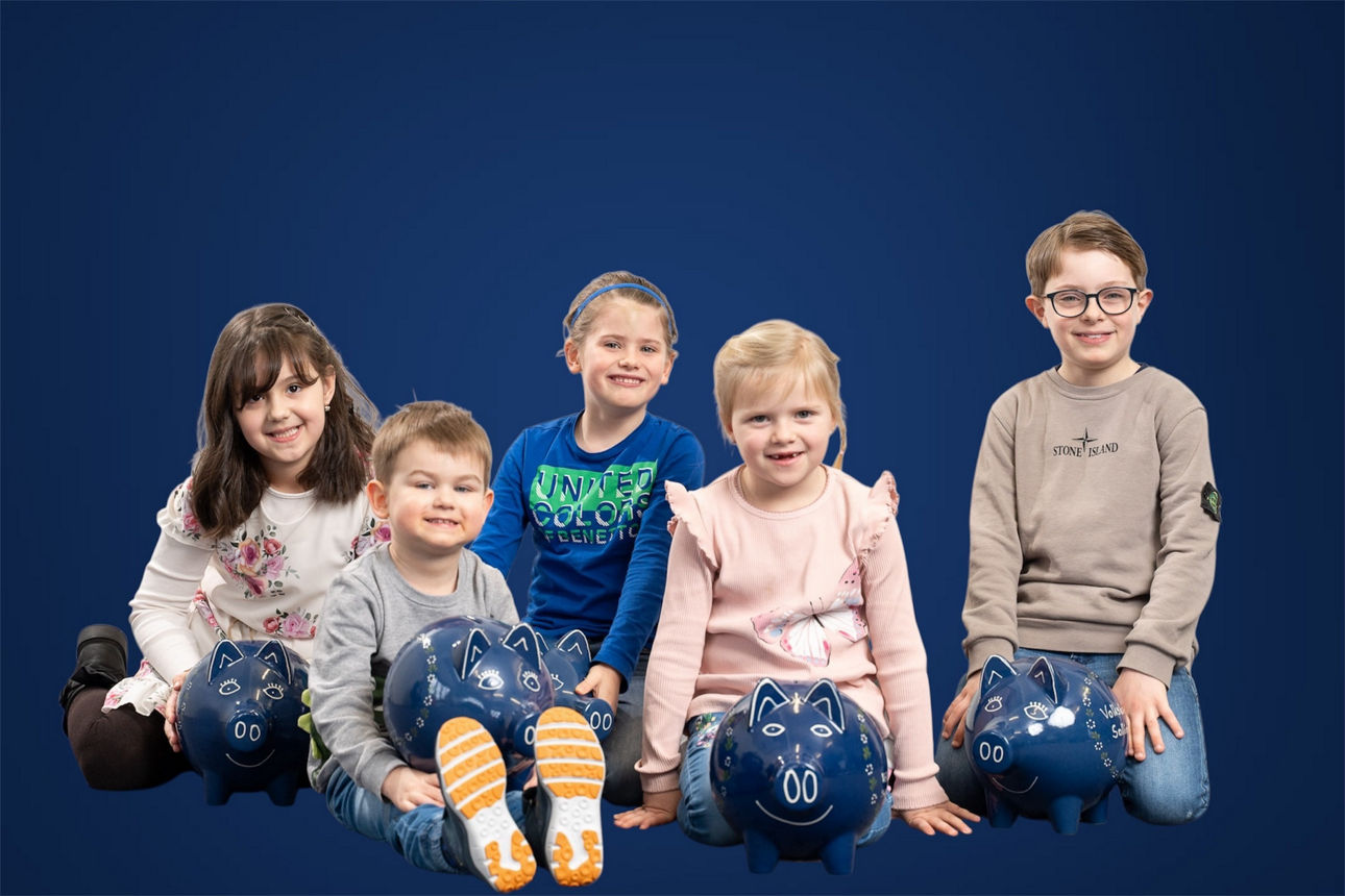 5 Kinder vor blauem Hintergrund mit Sparschweinen vor sich.