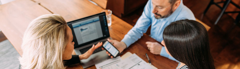Beraterteam am Handy und PC zur Besprechung