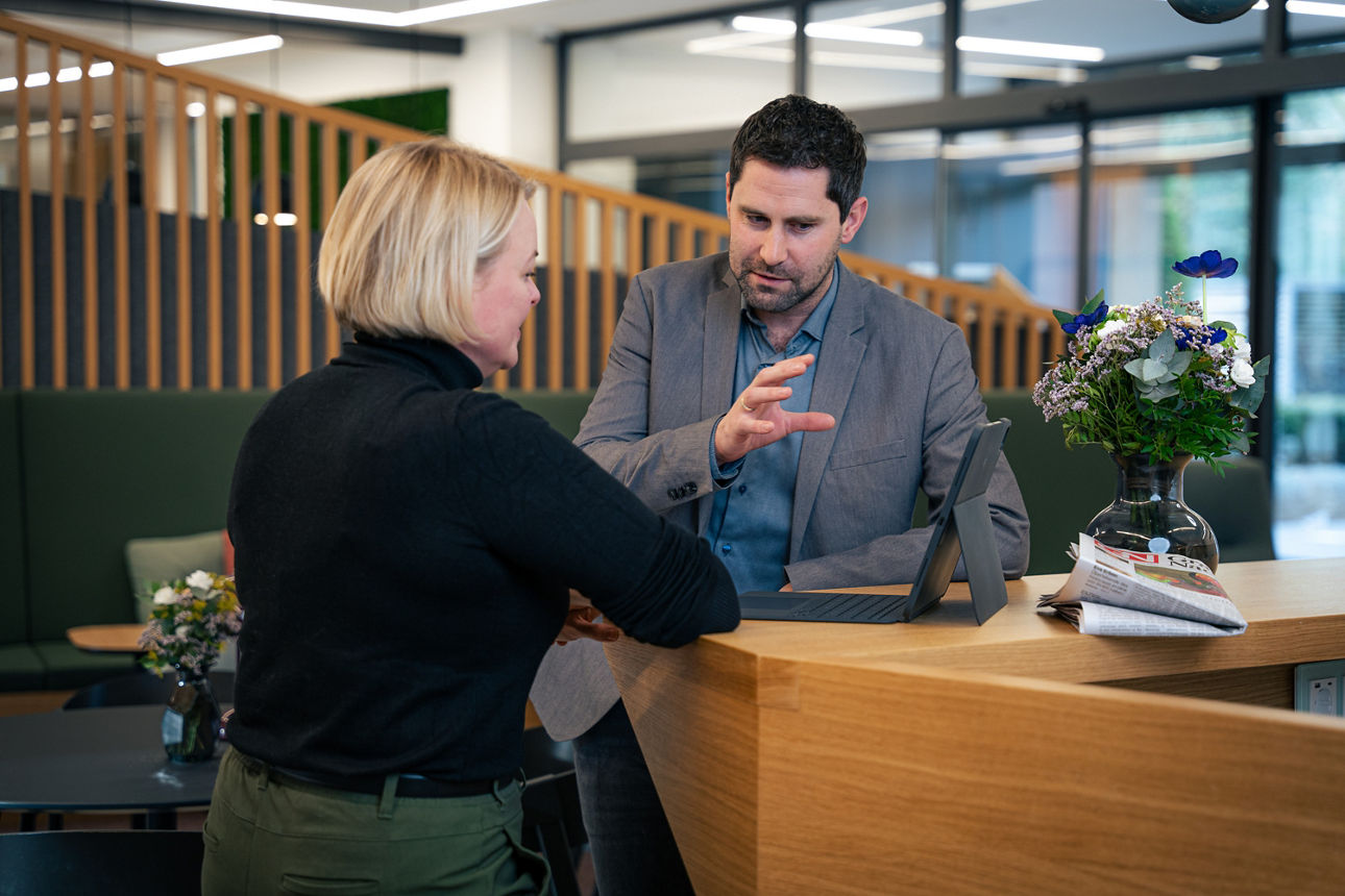 Praktikant beim Videodreh vor einer Leinwand
