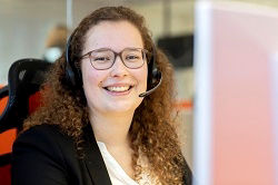Frau mit Headset lächelt in die Kamera