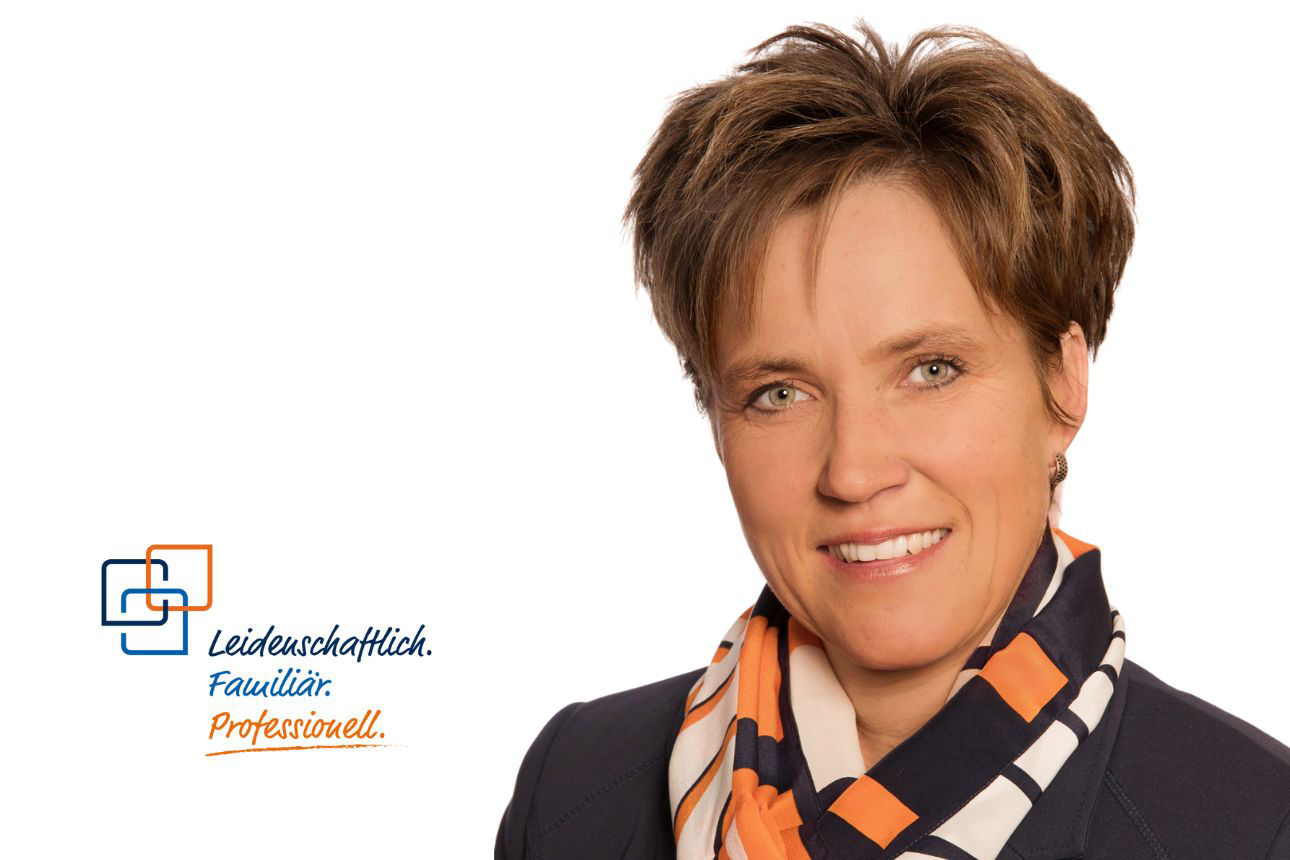 Porträt von Petra Demmel, einer lächelnden Frau mit kurzen braunen Haaren und einem gemusterten Tuch. Daneben das Firmenlogo und der Slogan "Leidenschaftlich. Familiär. Professionell."