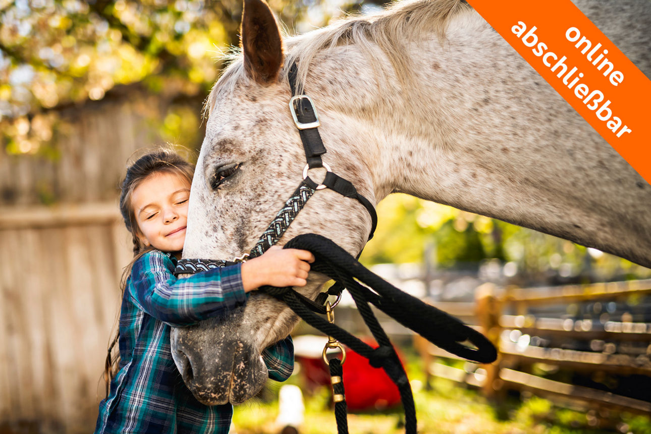 junges Mädchen kuschelt mit weißem Pferd