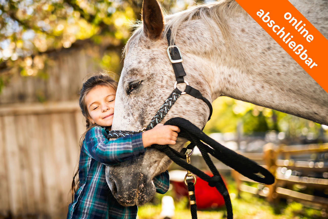 junges Mädchen kuschelt mit weißem Pferd