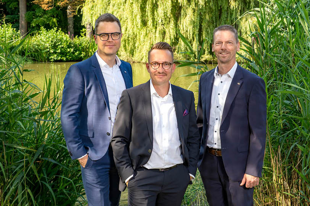 Drei Männer an einer blauen Bank