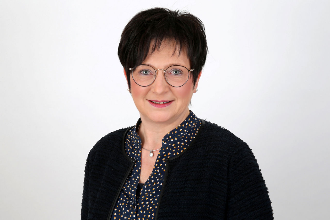Eine lächelnde Frau schaut in die Kamera.