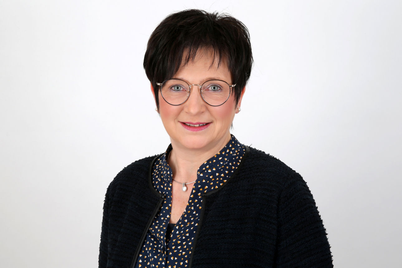 Eine lächelnde Frau schaut in die Kamera.
