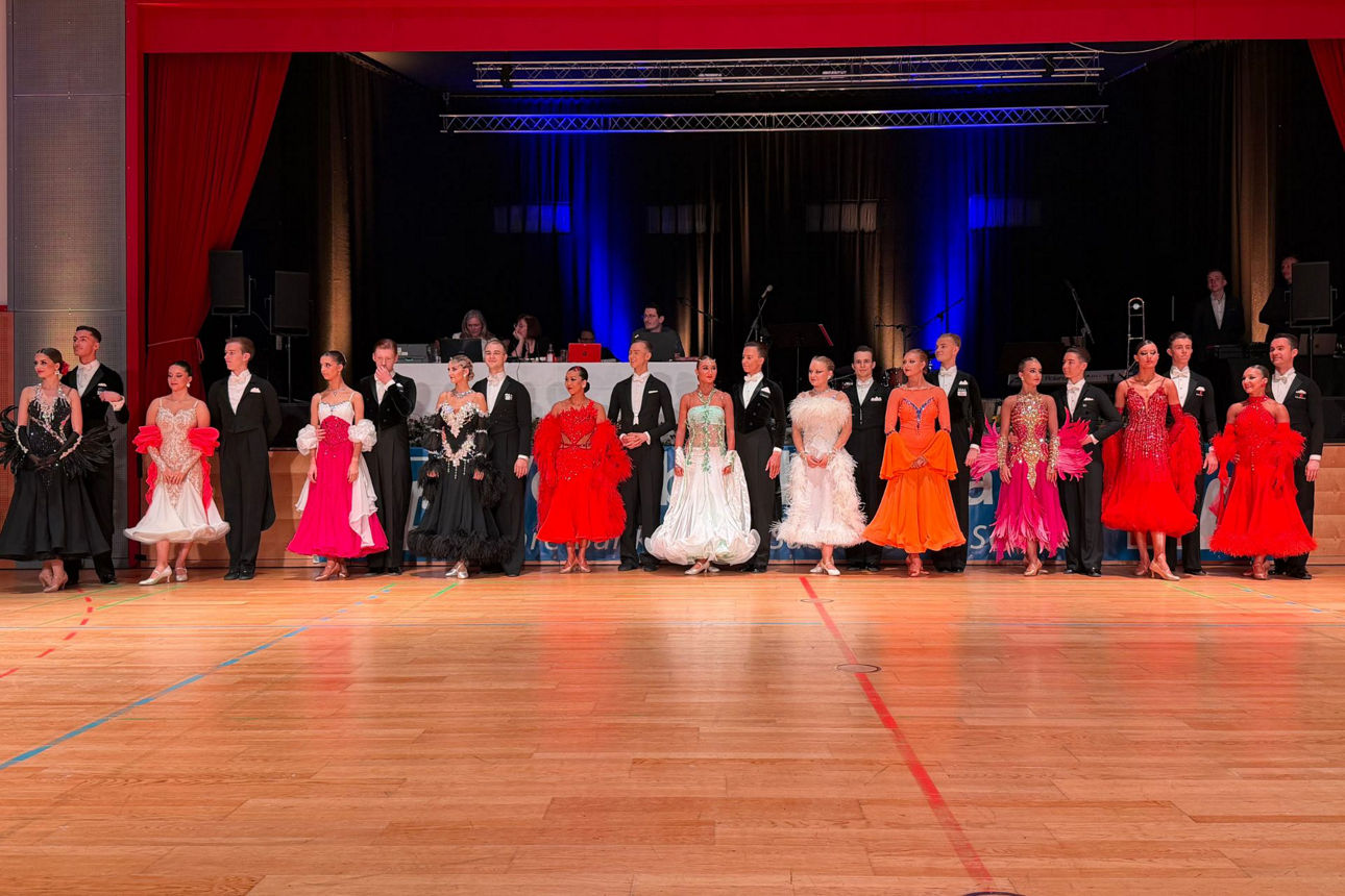 Mehrere Tanzpaare vor dem Tanz in glitzernden Kleidern