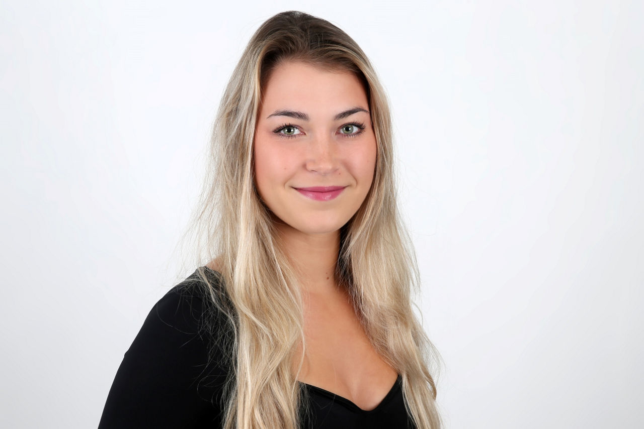 Eine lächelnder Frau schaut in die Kamera.