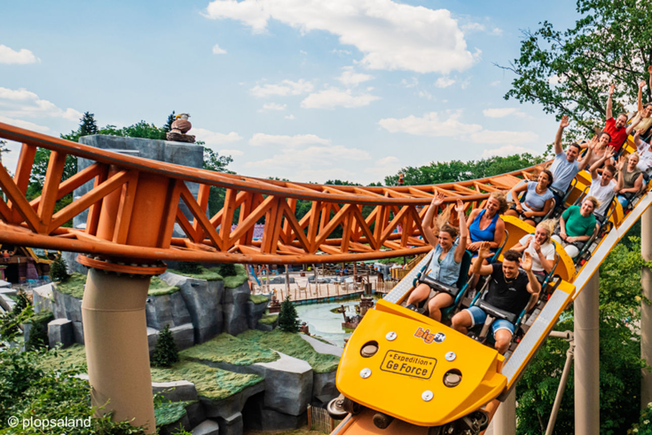 Mehrere Personen sitzen bei einer rasanten Fahrt in der Achterbahn Ge Force im Freizeitpark Plopsaland Deutschland.