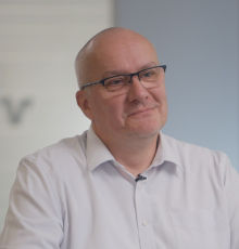 Ein Mann mit Brille lächelt